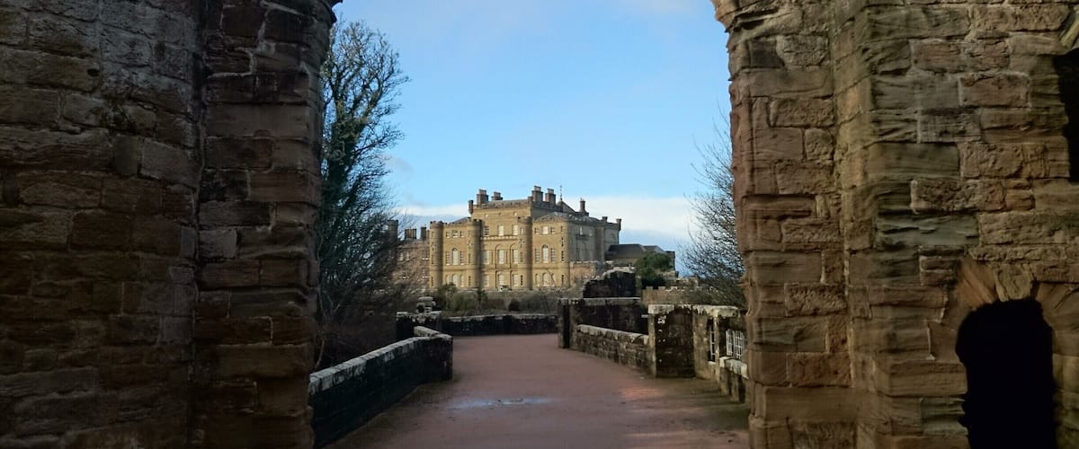 An arched stone structure leading to a historic building.