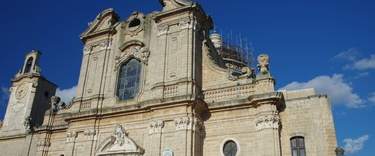 A historic building with ornate architecture, including a large wooden door and a statue.