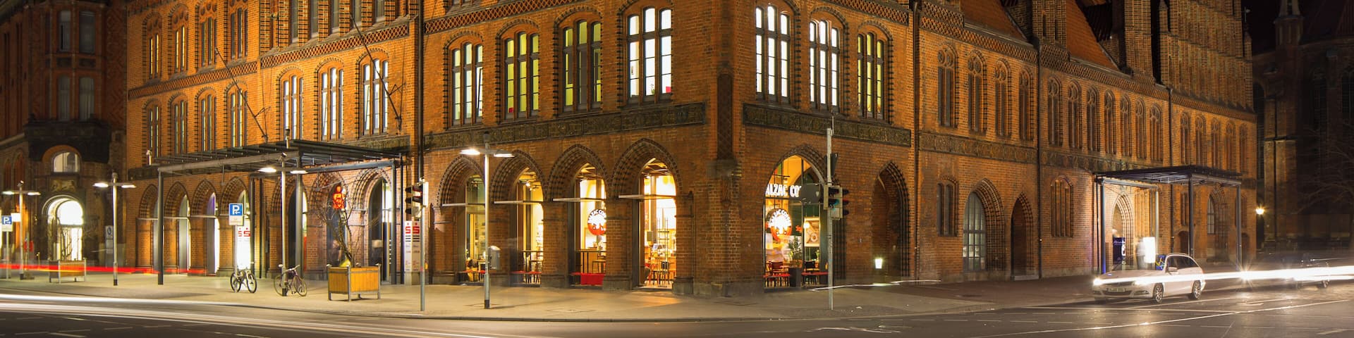 A historic building with intricate architecture and multiple spires, illuminated at night.