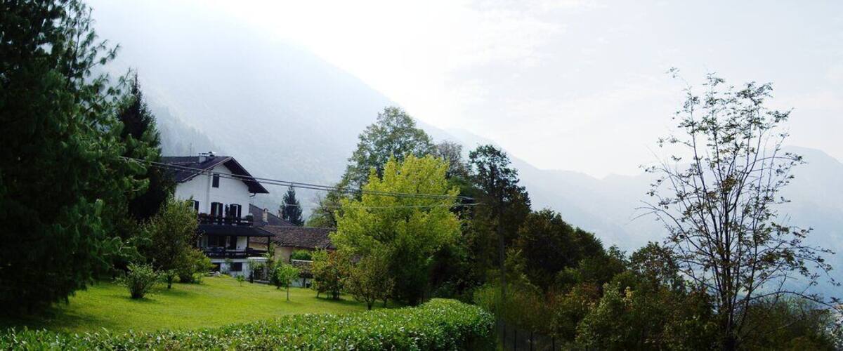 A mountainous landscape with a valley, a church, and a vineyard.