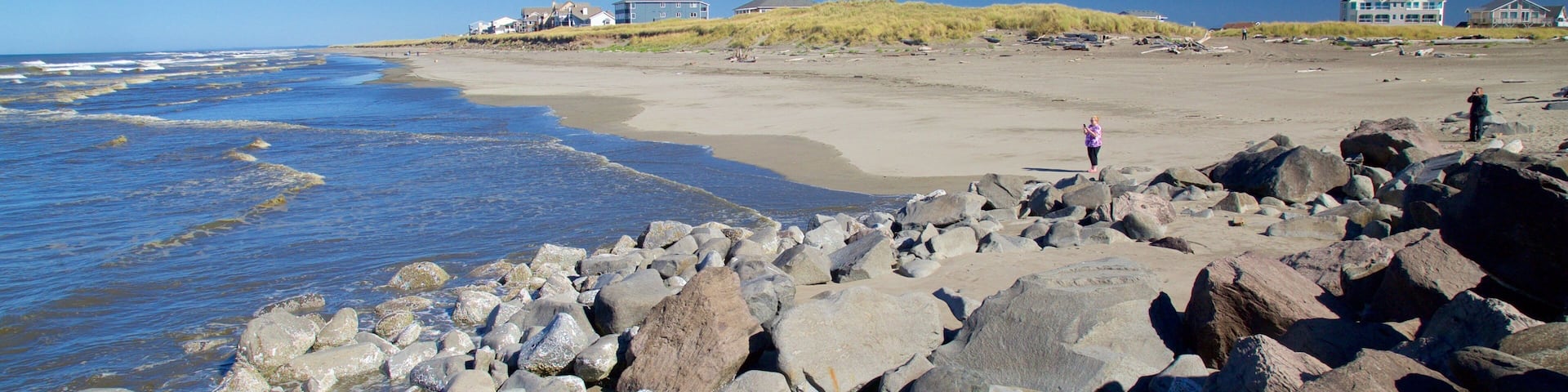 North Jetty which includes rocky coastline and a sandy beach