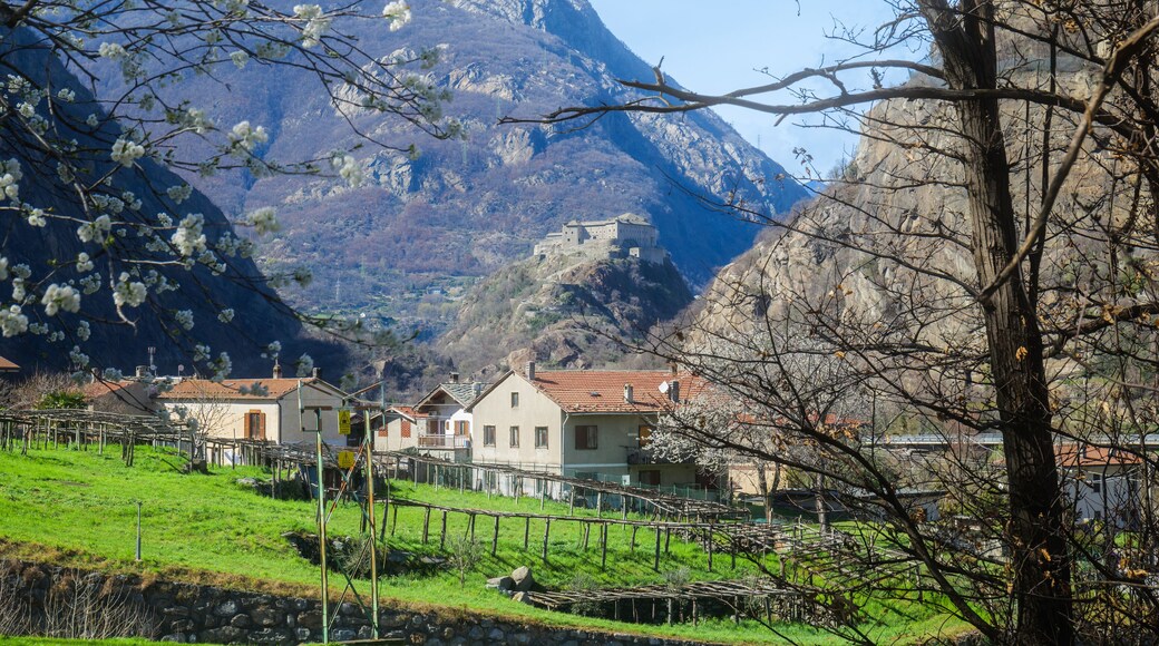 Donnas, Italy. Panoramic view of the Bard Fort from Chignas, in the municipality of Donnas. In the foreground country houses and green fields. 2023-03-25.
