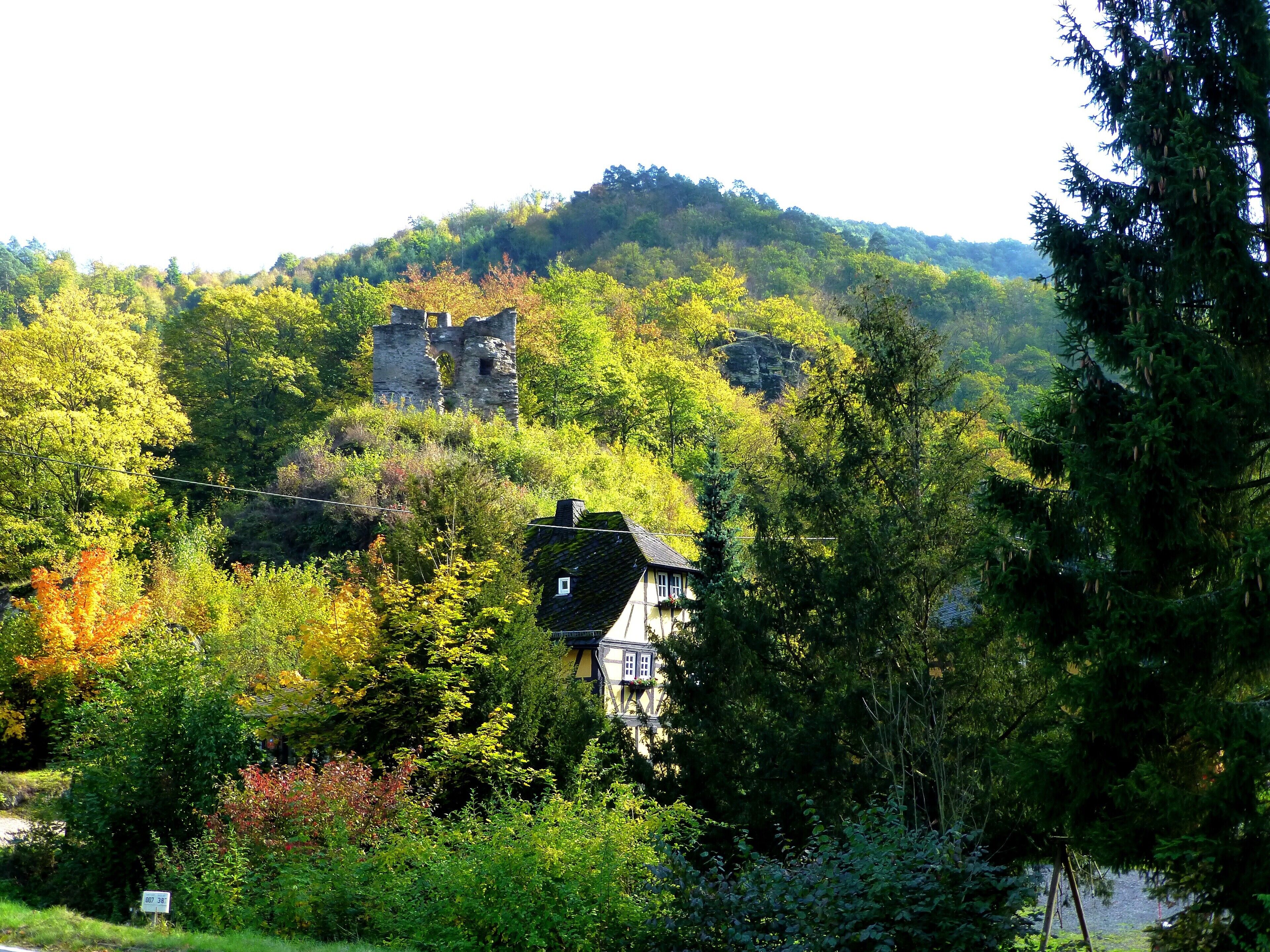 A historic stone building surrounded by lush greenery and trees.