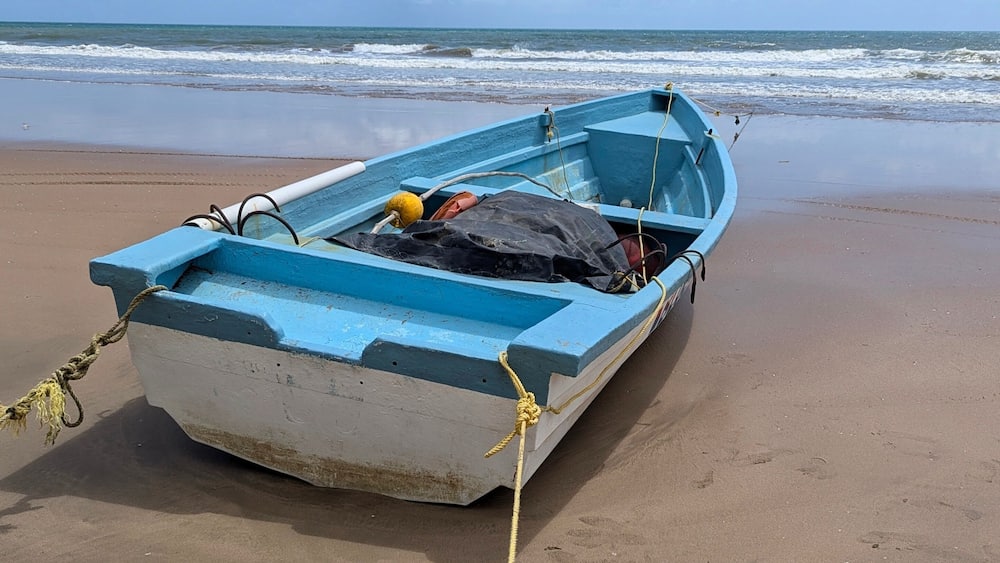 A wooden fishing boat or pirogue on the seashore of the Mayaro Beach, Trinidad and Tobago.
