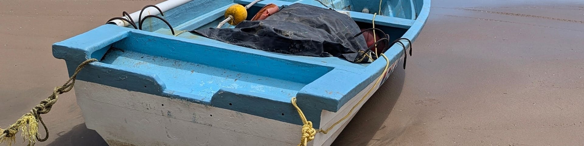 A wooden fishing boat or pirogue on the seashore of the Mayaro Beach, Trinidad and Tobago.