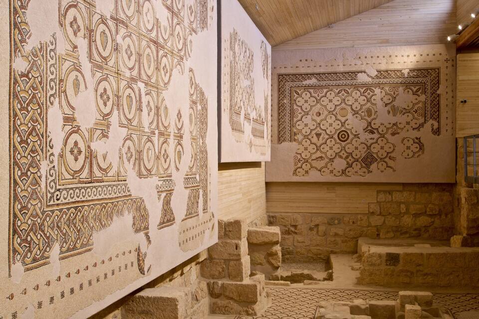 Padrões antigos em mosaicos nas paredes e soalho de pedra em um edifício histórico.