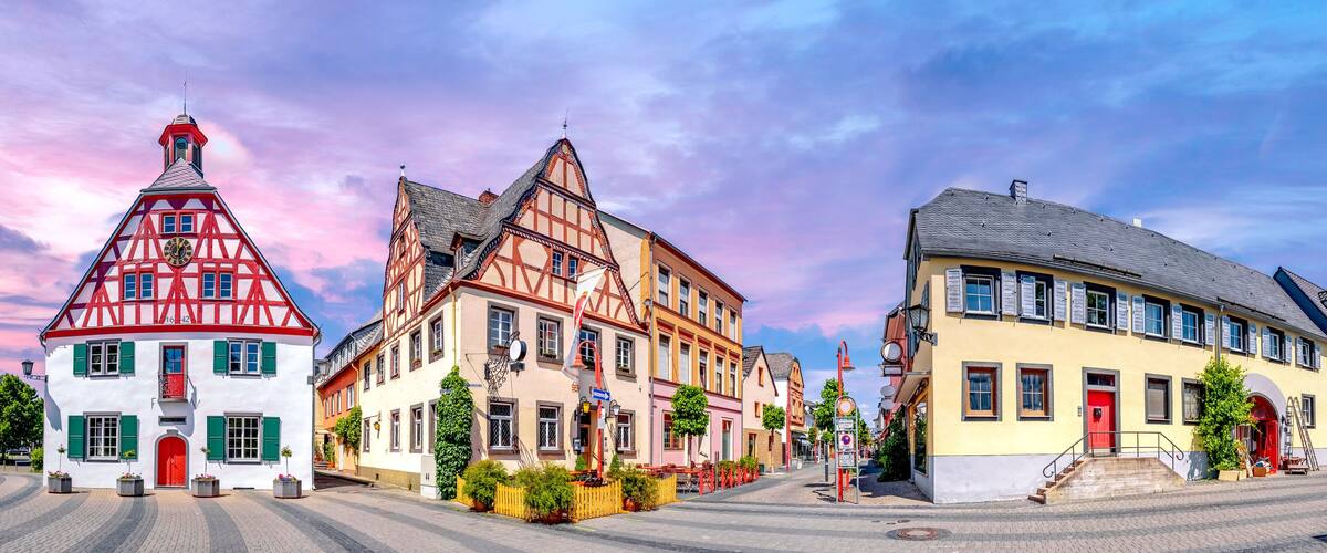 A European town square with traditional half-timbered houses and cobblestone streets.
