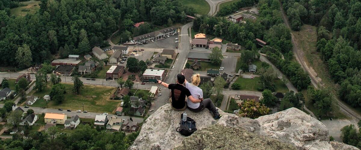 This is the view from atop the Pinnacle Overlook. it gives you a panoramic of Cumberland Gap (on your far left). From here it is easy to tell why settlers used this valley to head West. the view is sensational; You get about a 200 degree view of the western ranges of the smoky mountains. Two crazy people decided to climb over the railing and down to the edge of the cliff. A few hundred feet below is the small town of Cumberland.