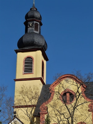 Església amb una torre del rellotge, una cúpula i una façana groga.