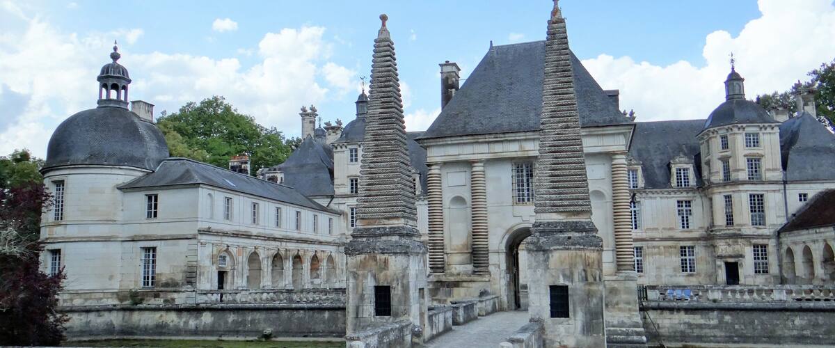 A historic building with two tall, stone spires and a central courtyard.