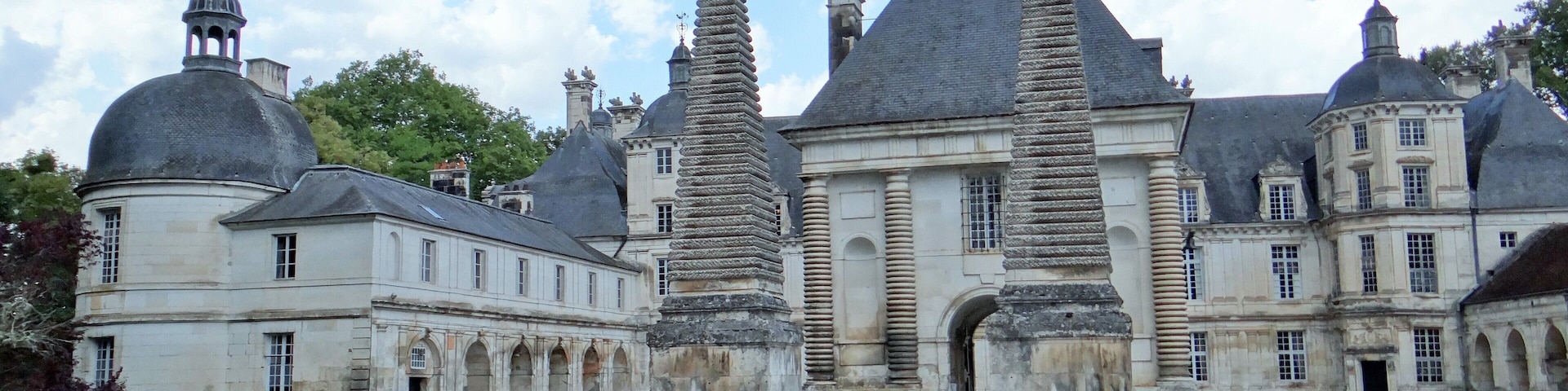 A historic building with two tall, stone spires and a central courtyard.