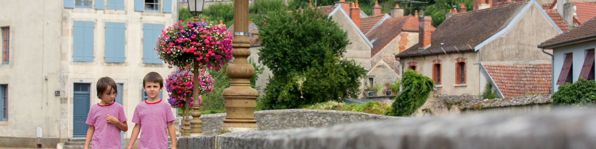 Children standing in front of flower pots in the town of Chatillon sur Seine