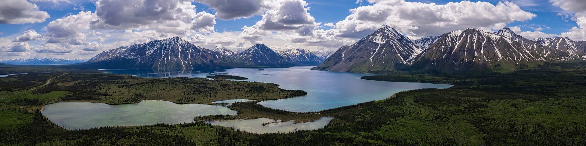 A mountainous landscape with a lake and forested areas.