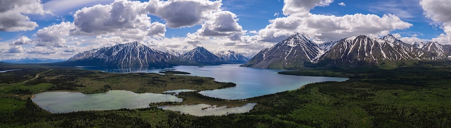 Un paisaje montañoso con un lago y zonas boscosas.