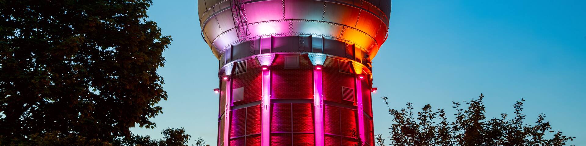 Historic water tower in Neunkirchen (Saarland, Germany), part of ancient steel mill and blast furnace called “Altes Hüttenareal“. Public sight and tourist attraction at evening twilight at blue hour.