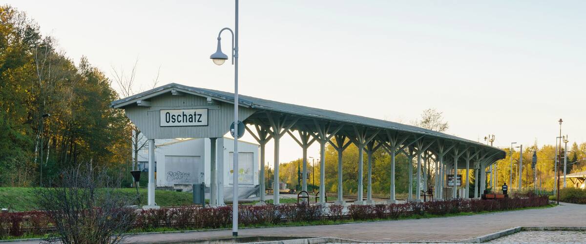 A covered waiting area with a sign reading "Oschatz".