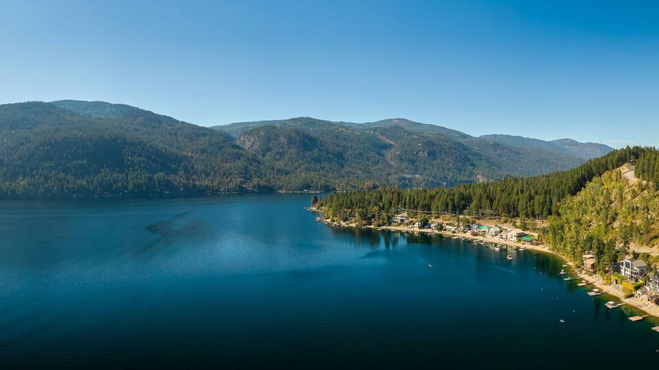 A lake surrounded by mountains and a small coastal village.