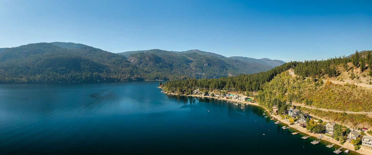 A lake surrounded by mountains and a small coastal village.