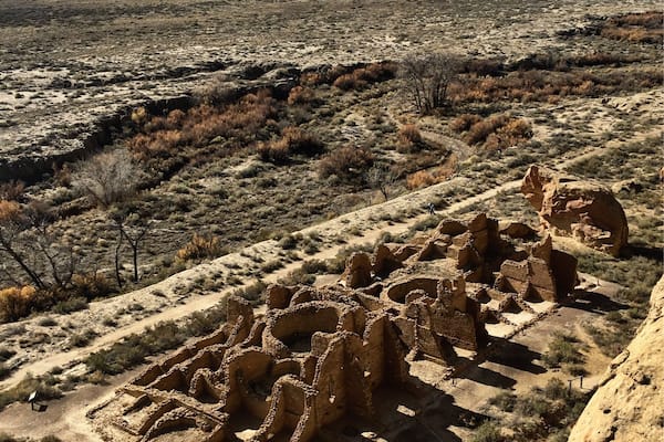A desert landscape with ancient ruins in the foreground and a flat terrain in the background.
