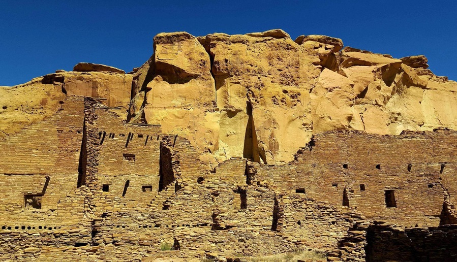 Ancient cliff dwellings with a clear blue sky.