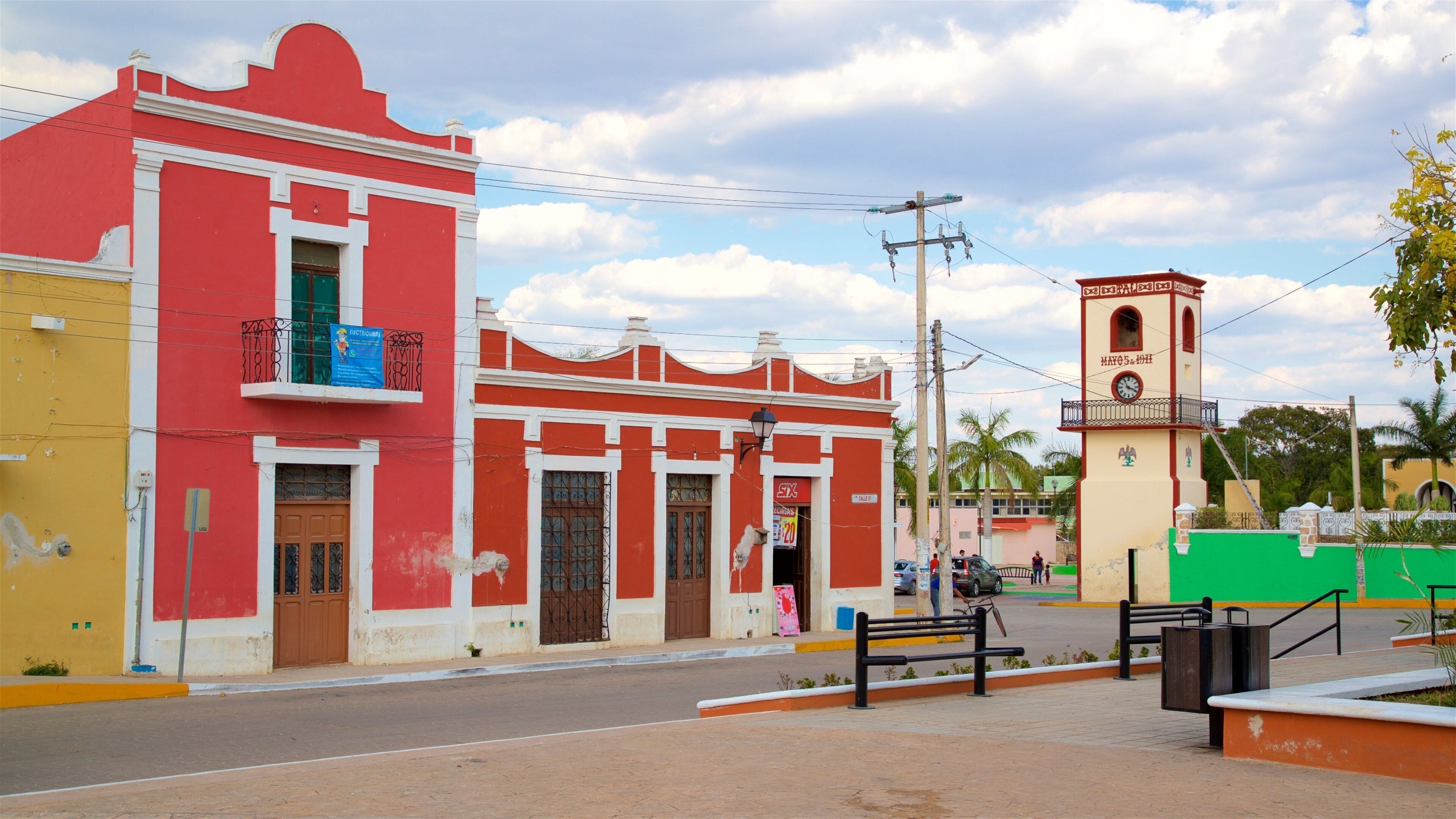 Una calle con edificios coloridos, una torre del reloj y un cielo despejado.