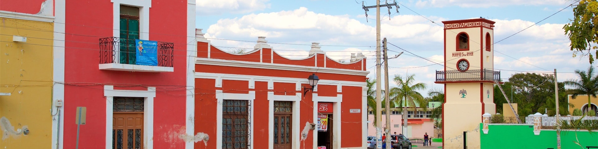 Una calle con edificios coloridos, una torre del reloj y un cielo despejado.