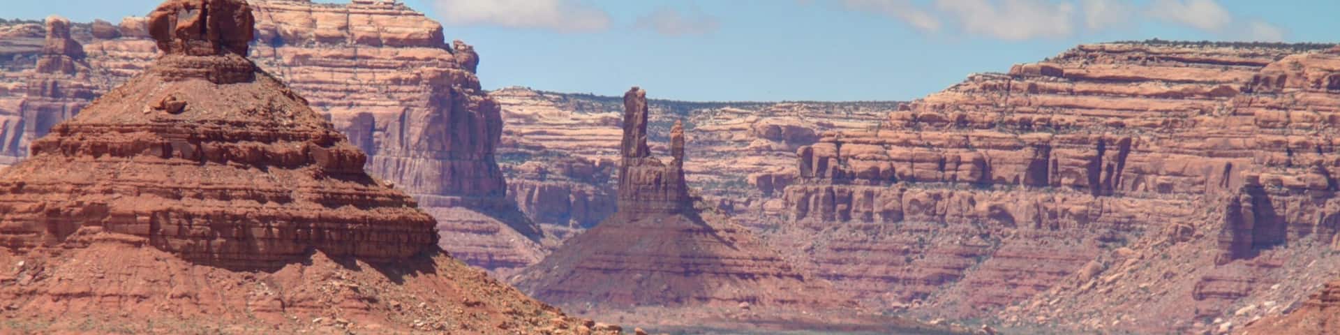 A desert landscape with rock formations and sparse vegetation.