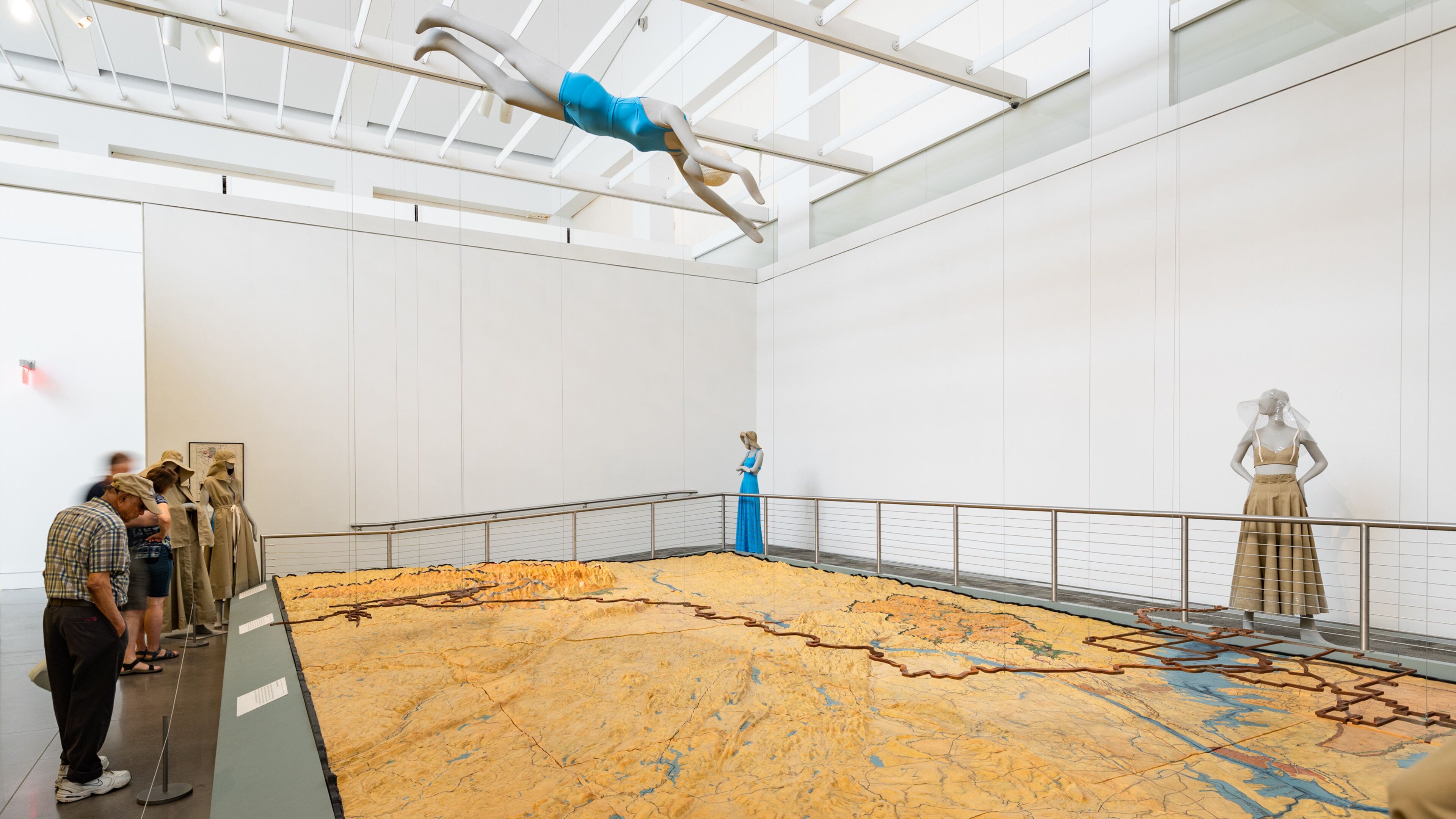 Queens Museum of Art featuring interior views and art as well as a small group of people