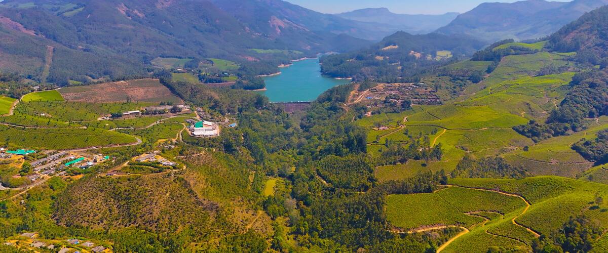 A mountainous landscape with a lake, terraced fields, and a small settlement.