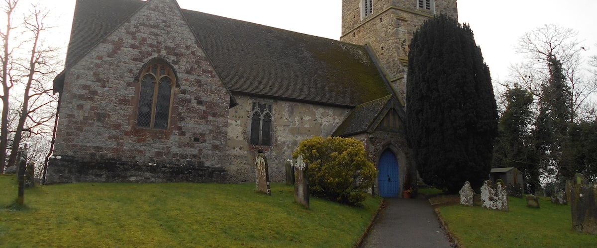 A stone church with a tall tower and a blue door.