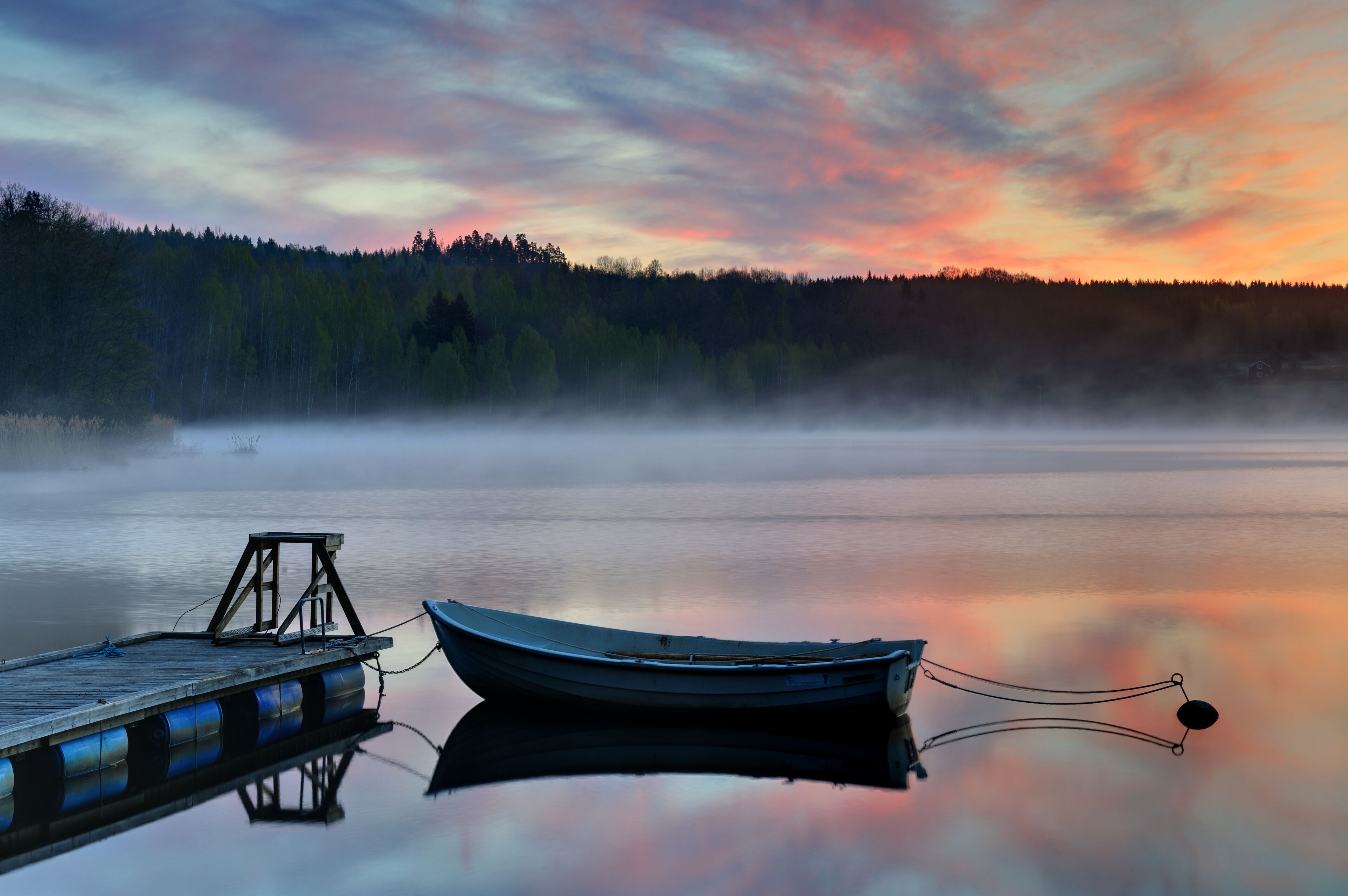 Empty boat moored to jetty at sunset, Båtsjön, Åtvidaberg, Östergötland, Sweden, Europe