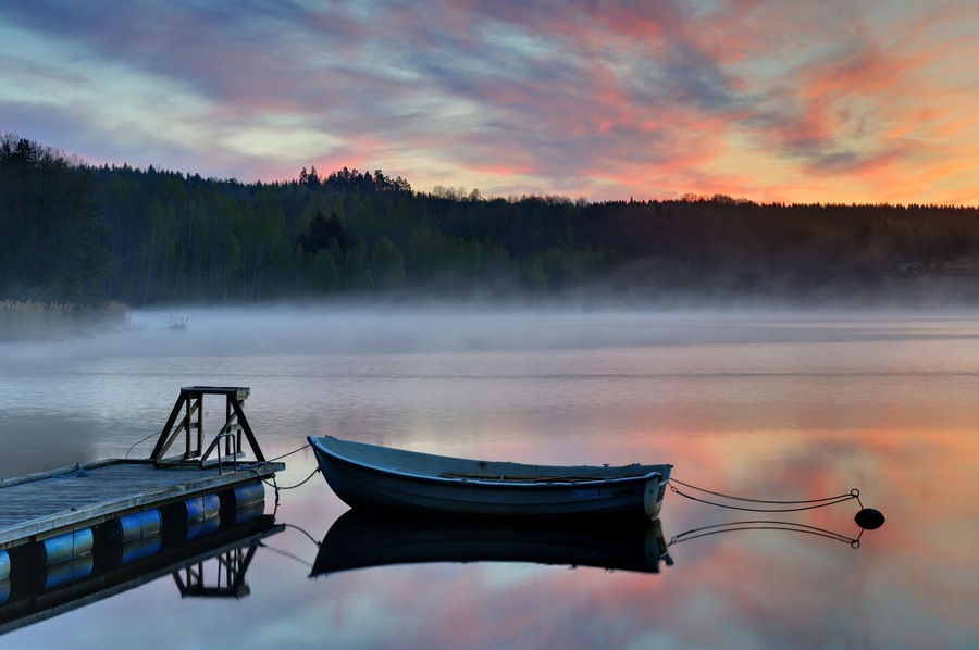 Empty boat moored to jetty at sunset, BĂ„tsjön, Ă
tvidaberg, Ăstergötland, Sweden, Europe