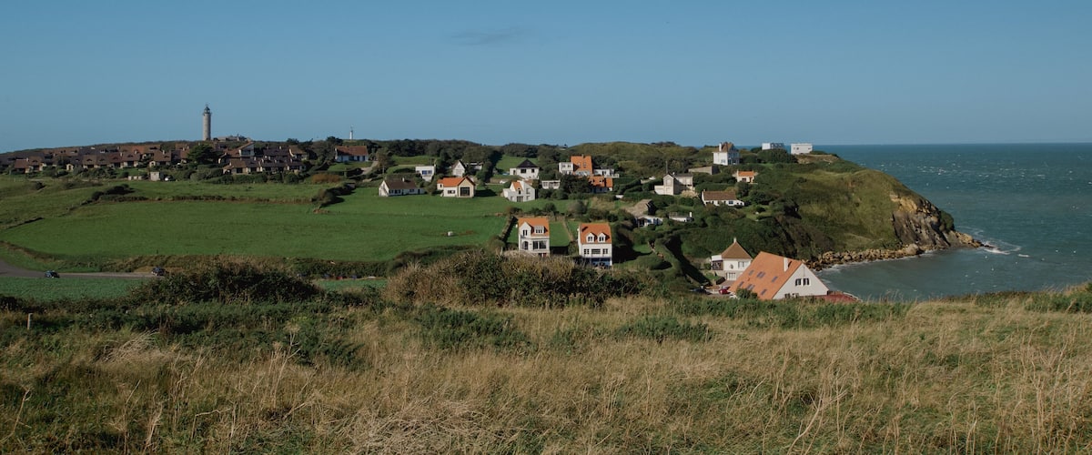 A coastal village with houses on a hillside overlooking the sea.