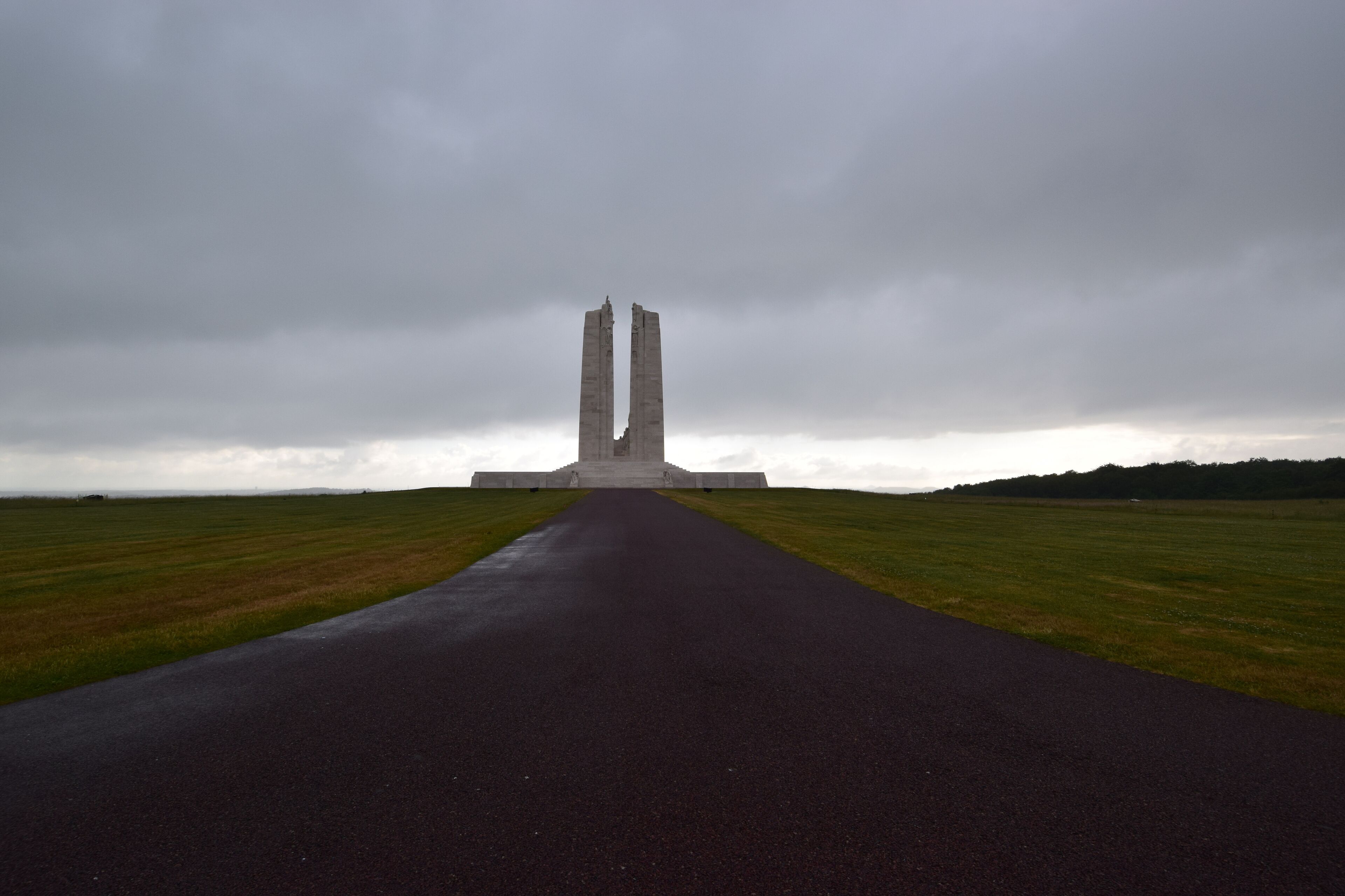 A monument with two tall, narrow towers in a field.