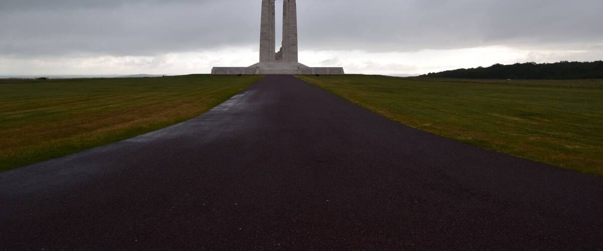 A monument with two tall, narrow towers in a field.
