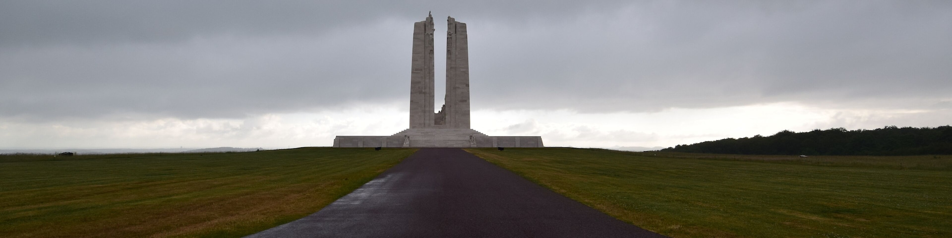 A monument with two tall, narrow towers in a field.