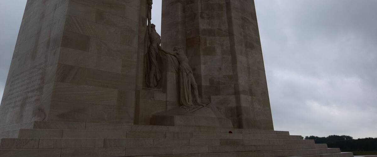 A large stone monument with a statue on top and steps leading up to it.