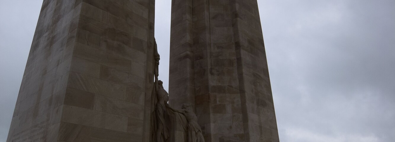 A large stone monument with a statue on top and steps leading up to it.