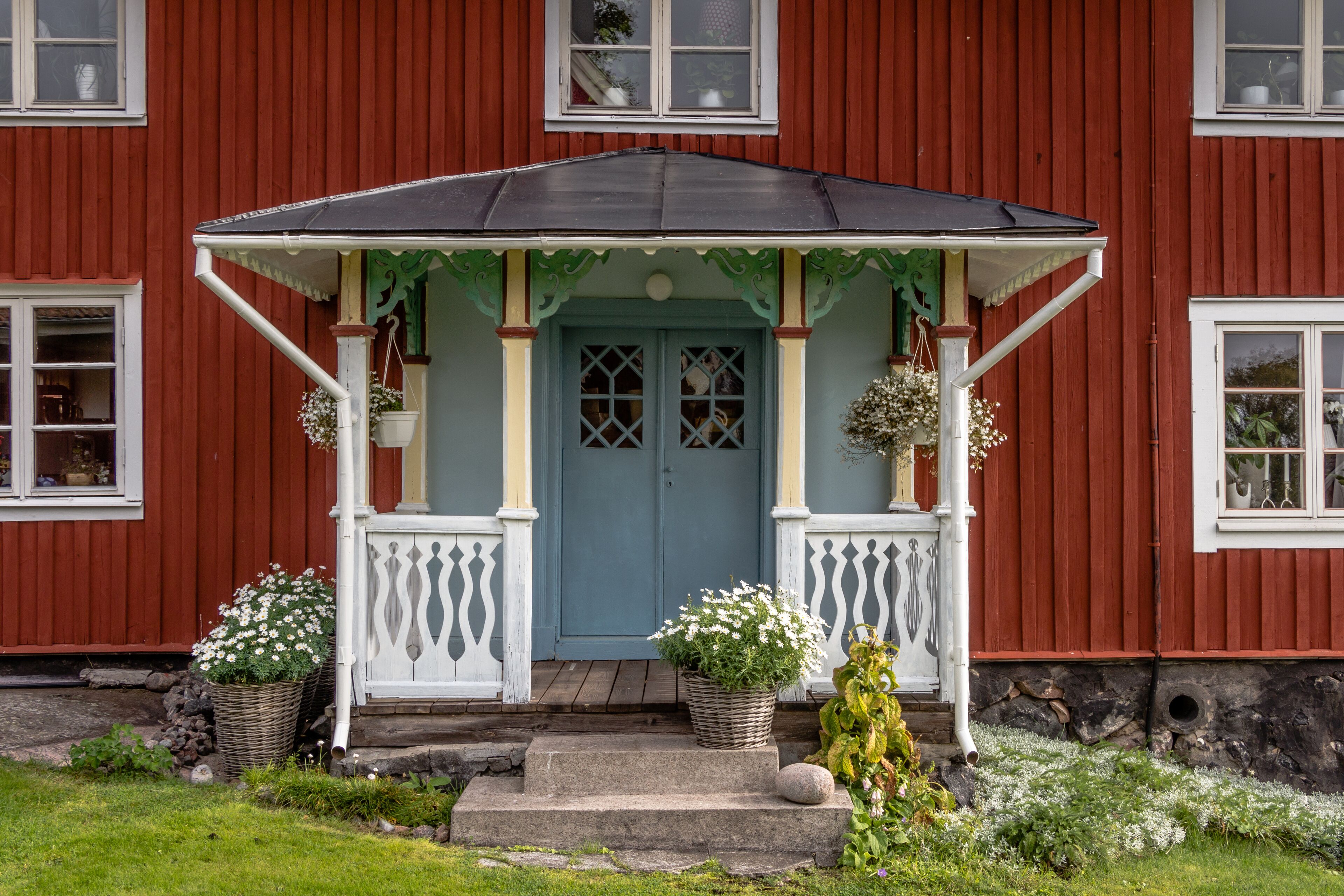 With flowers decorated facade Rof a ed cottage on the island Harstena in Sweden