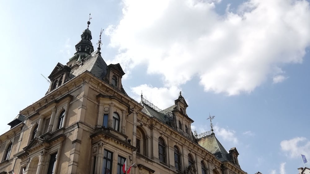 A historic building with ornate architecture and multiple flags.
