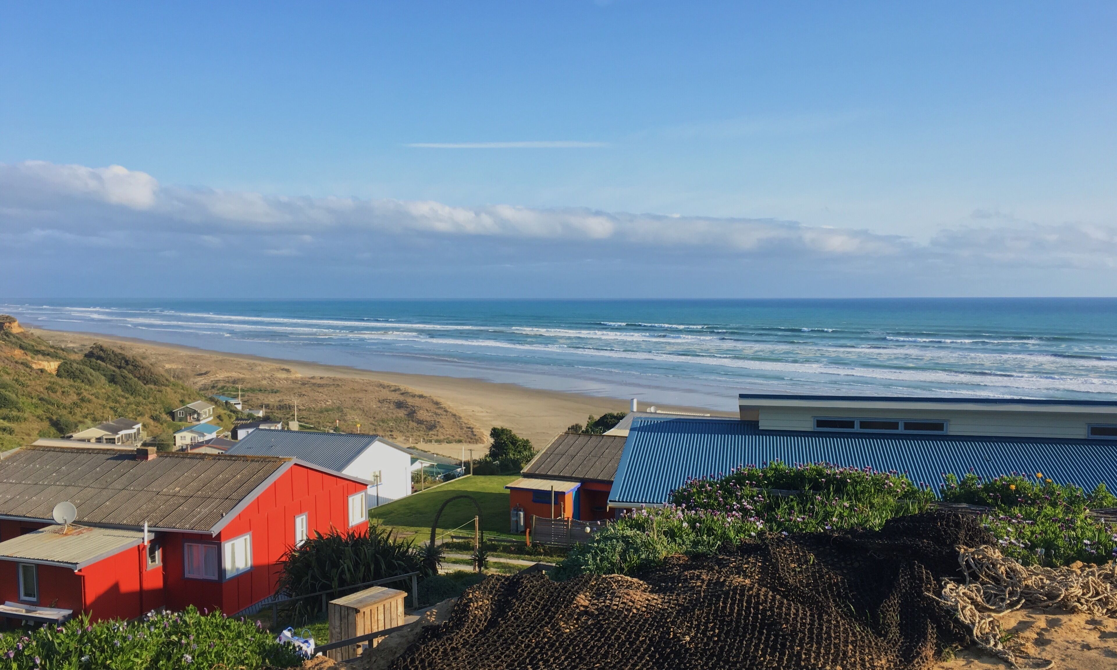Un paisaje costero con casas, una playa y el océano.