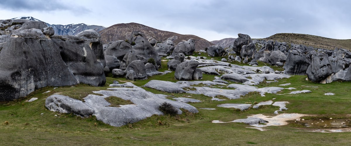 A rocky landscape with large boulders and a grassy field.