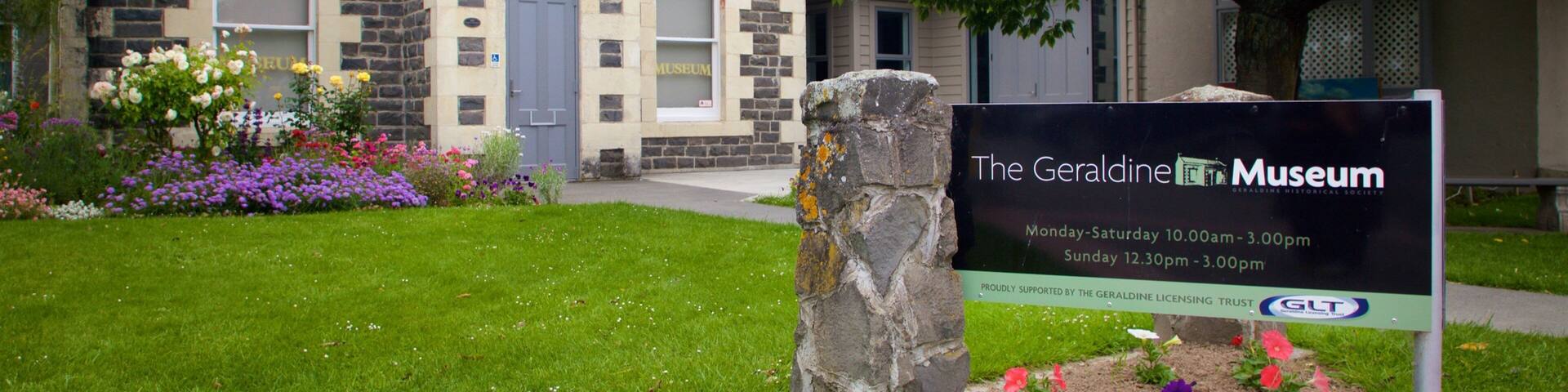 A town hall building with a museum sign in front.