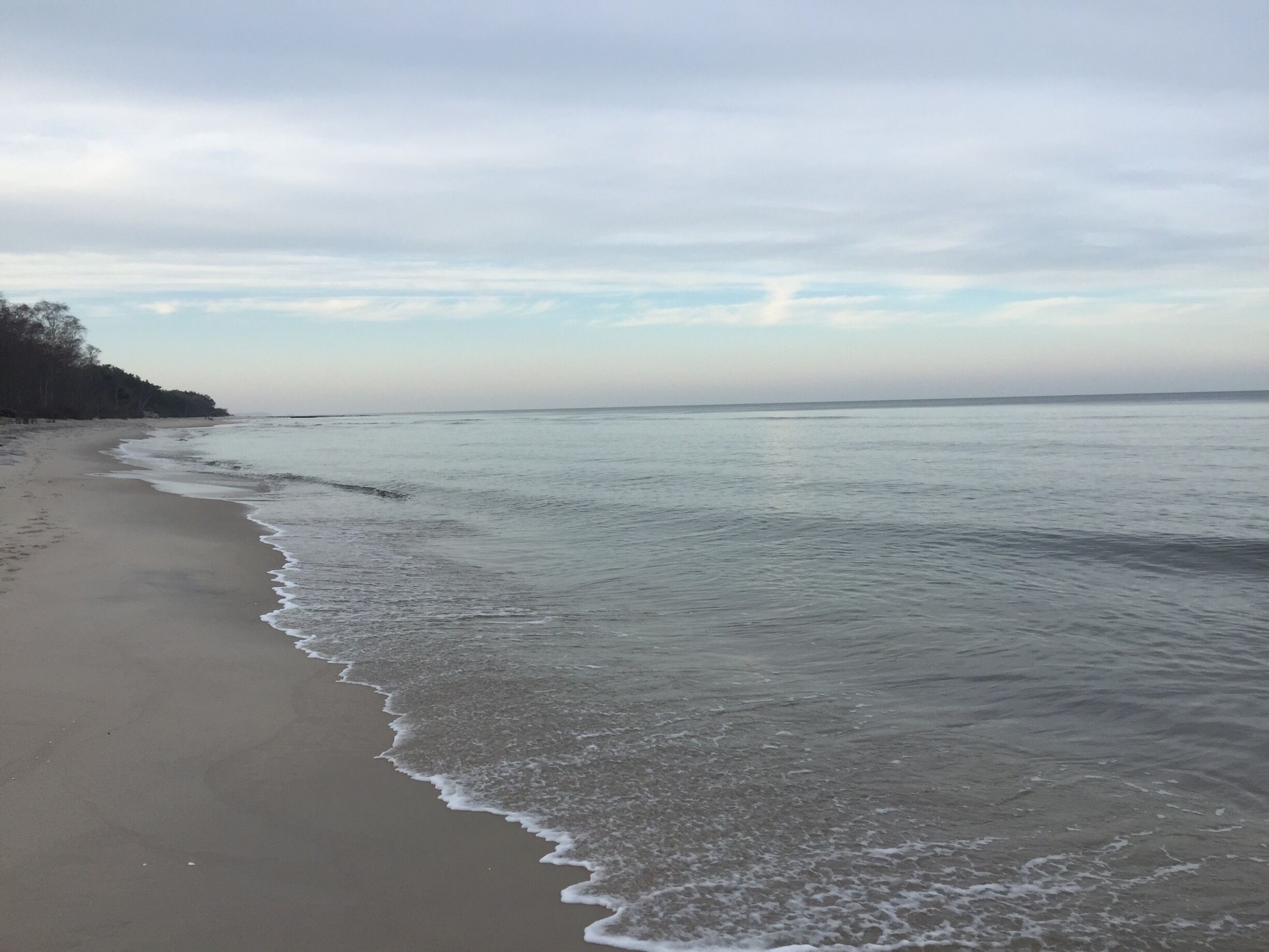 A beach with gentle waves and a clear sky.
