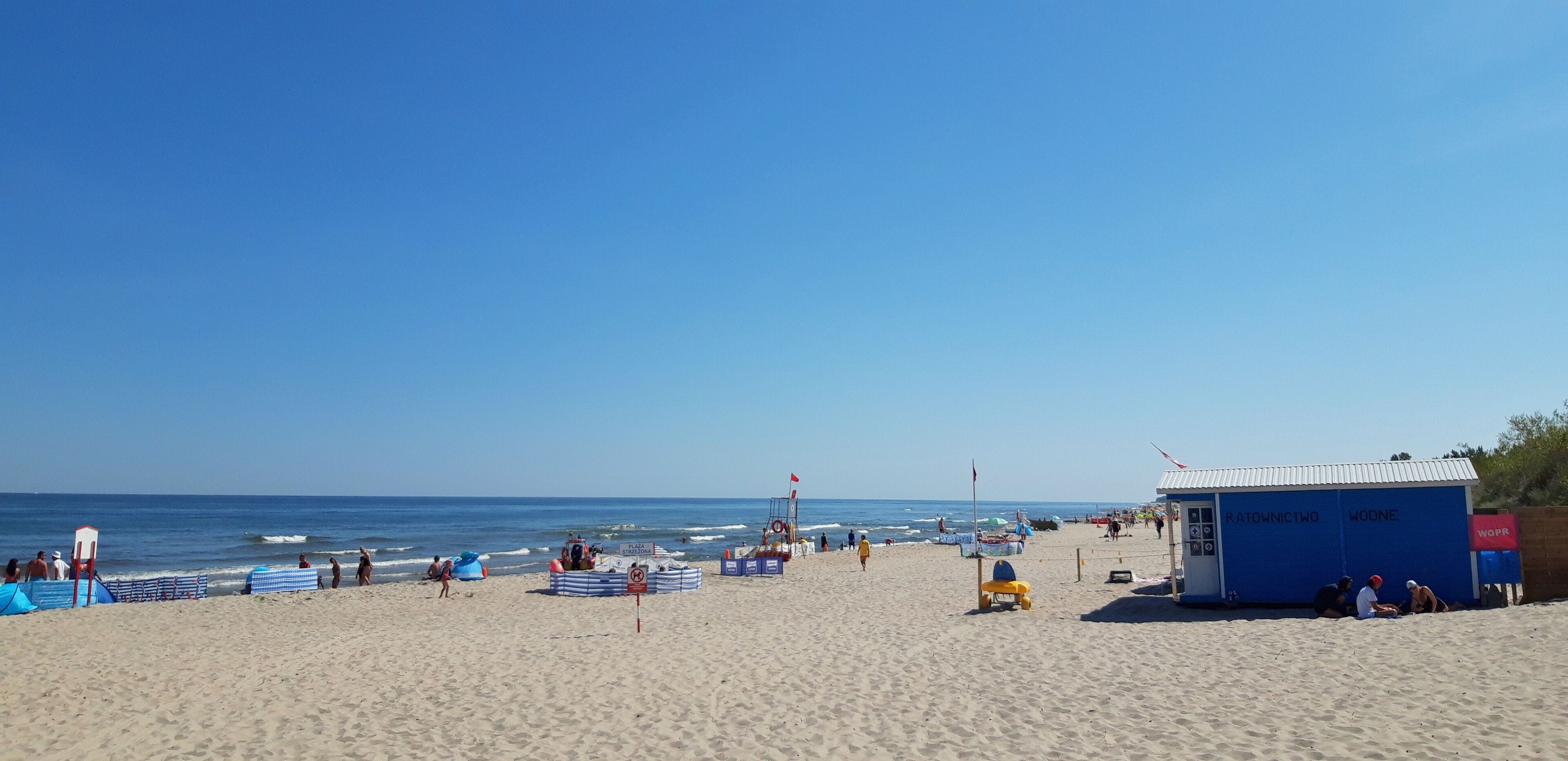 Kuźnica, Poland – August 13, 2020: People enjoying white sand and blue waters of a Baltic beach on a sunny summer day
