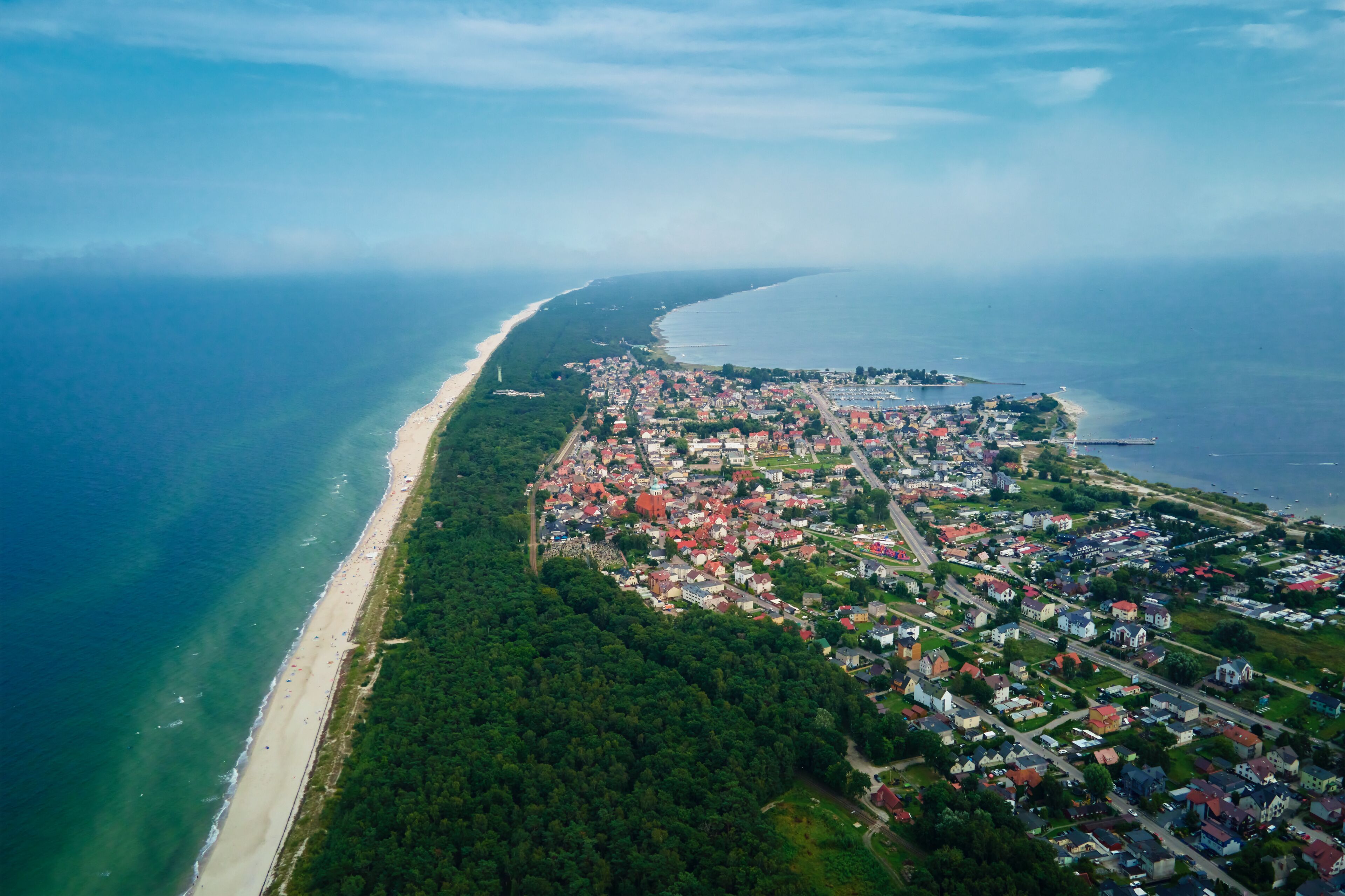 Birds eye view of sea landscape with sandy beach and Jastarnia city on Hel peninsula. Baltic Sea coast in Poland. Resort town in the summer season