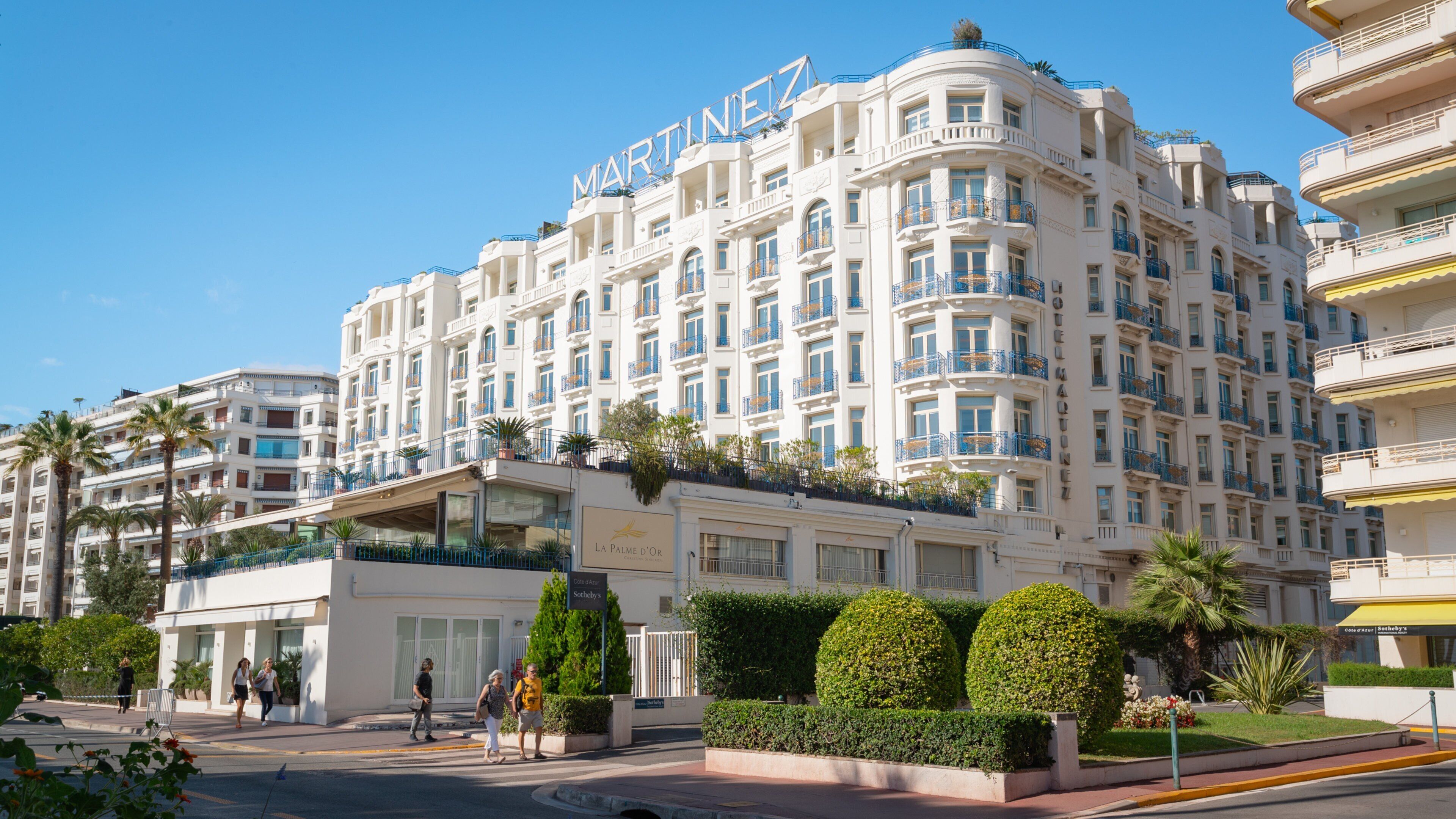 A large, multi-story hotel with balconies and a sign reading "MARTINEZ".