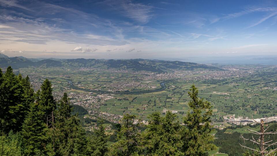 A mountainous landscape with a valley, a river, and a town.