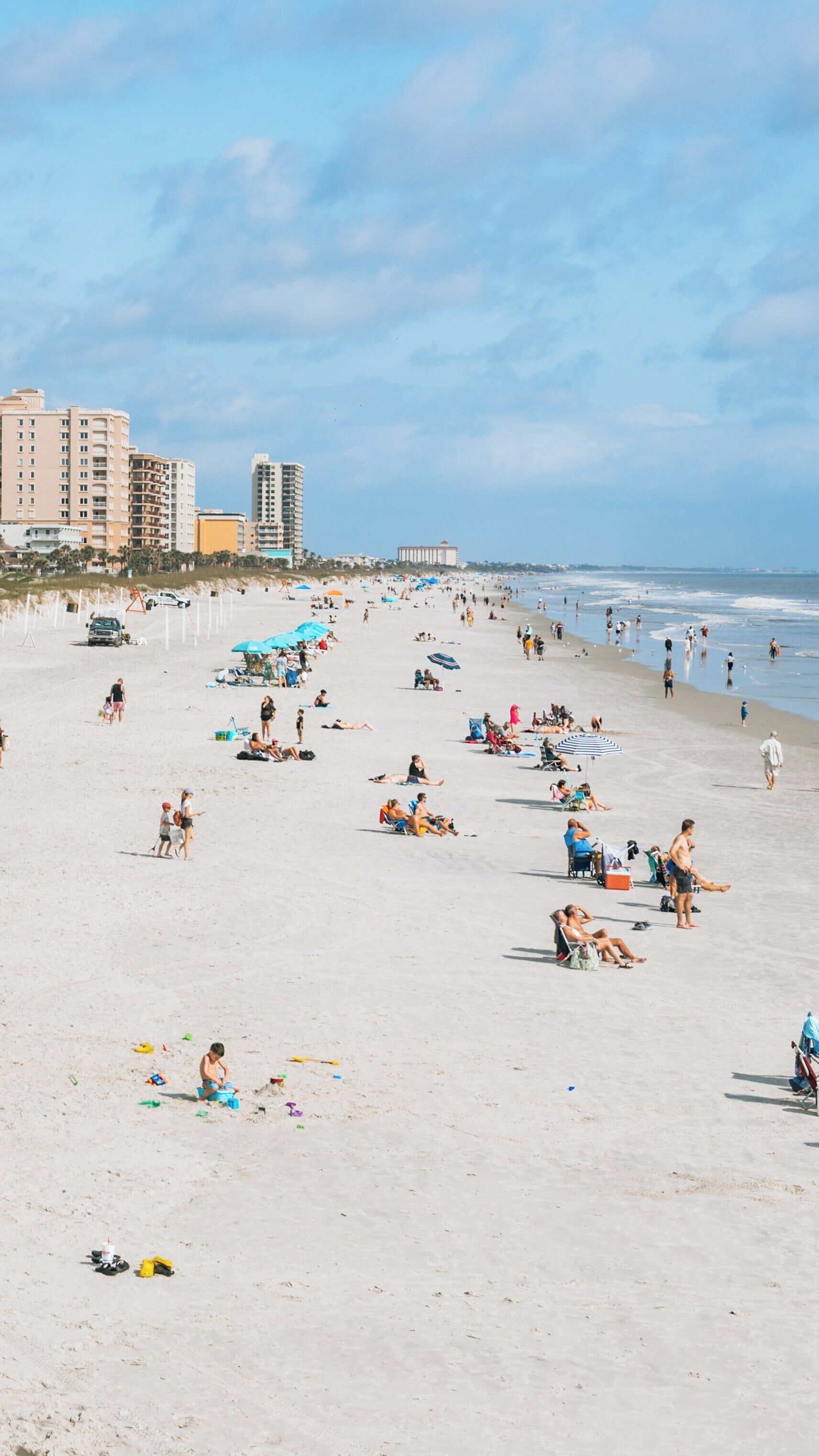 Jacksonville Beach Pier offers a vibrant day at the beach with families and visitors enjoying sun, sand, and surf in sunny Florida