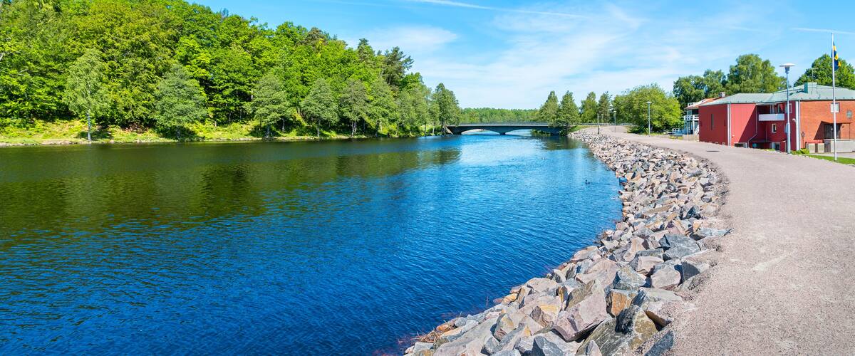 A river with a stone embankment and a red building on the right.